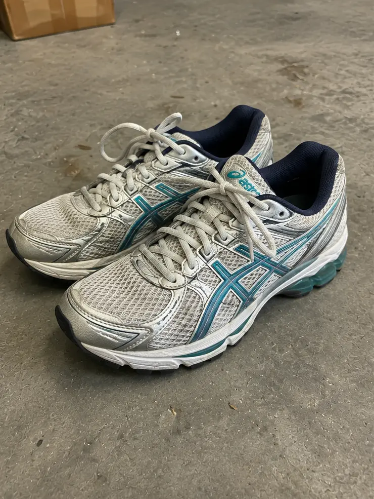 Unedited pair of used women's sneakers before ListingPack AI cleanup
